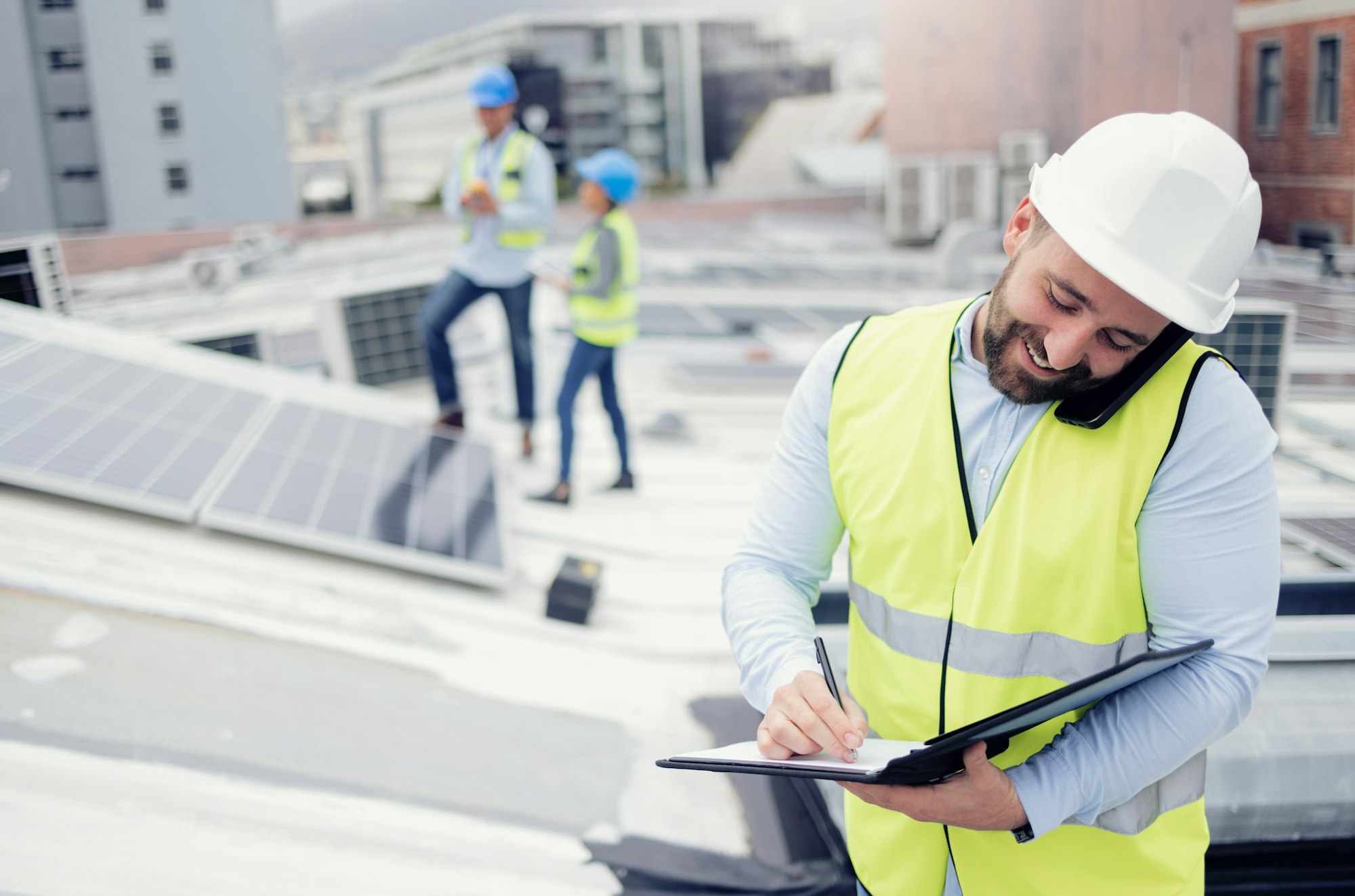 Construction, phone call and businessman writing checklist during building inspection on the roof.