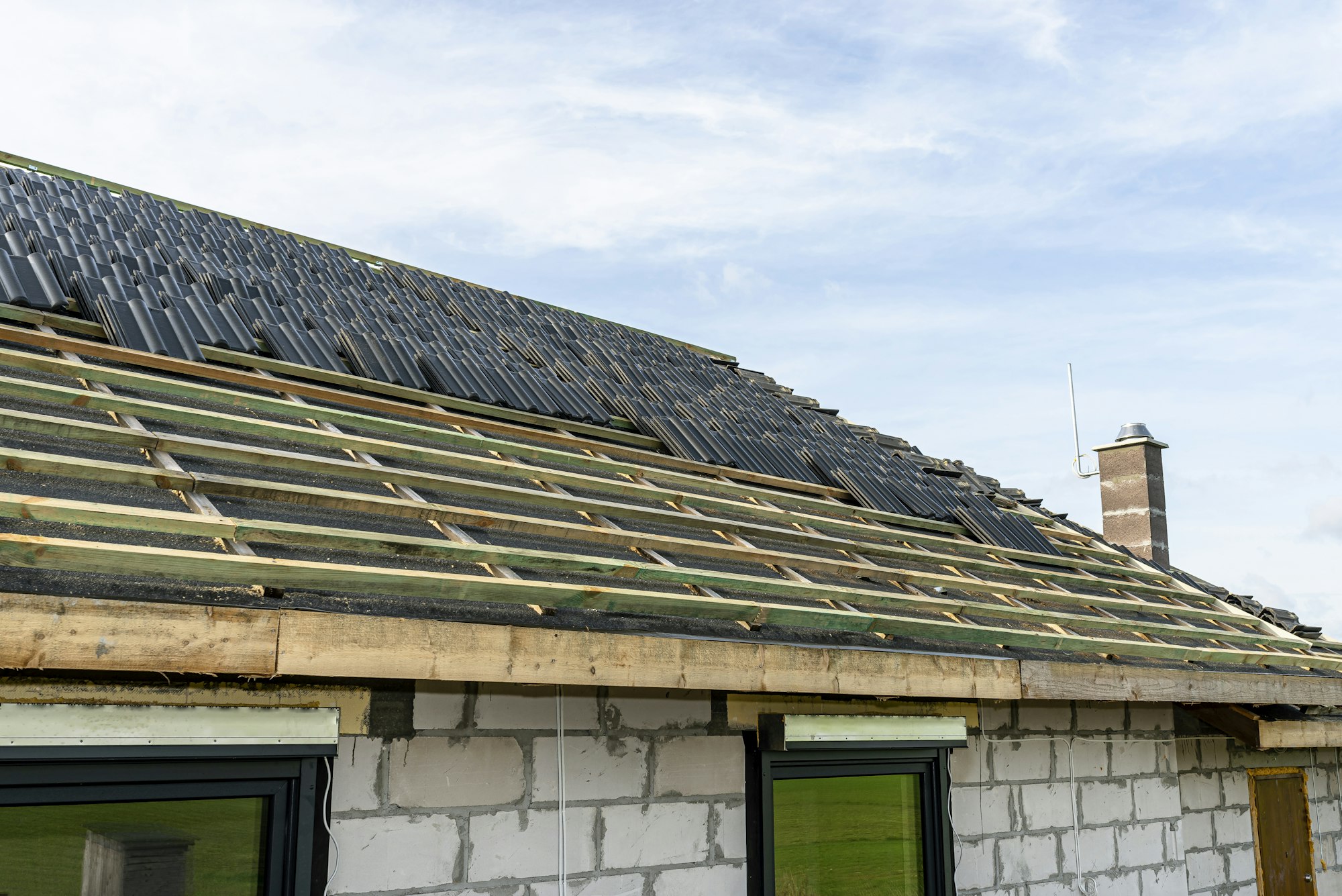 Roof ceramic tile arranged in packets on the roof on roof battens. laying tiles on a boarded roof.